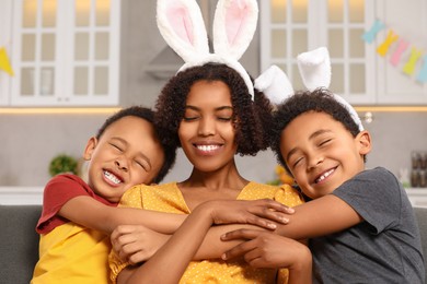 Happy African American mother and her cute children in kitchen