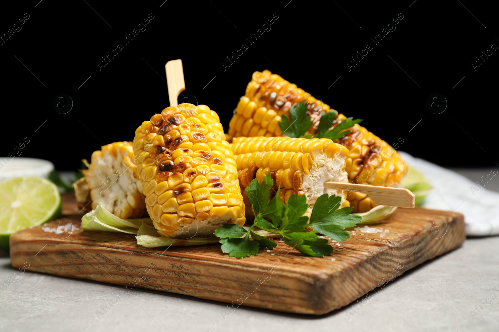 Photo of Tasty grilled corn cobs on light table, closeup