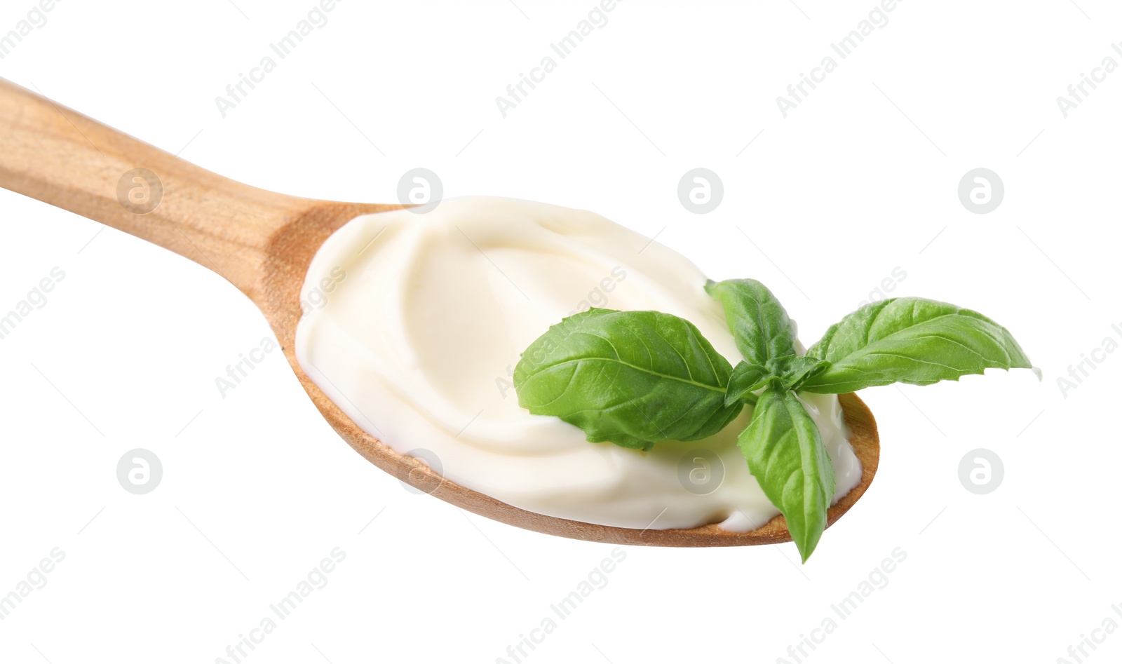 Photo of Wooden spoon with tasty mayonnaise and basil isolated on white