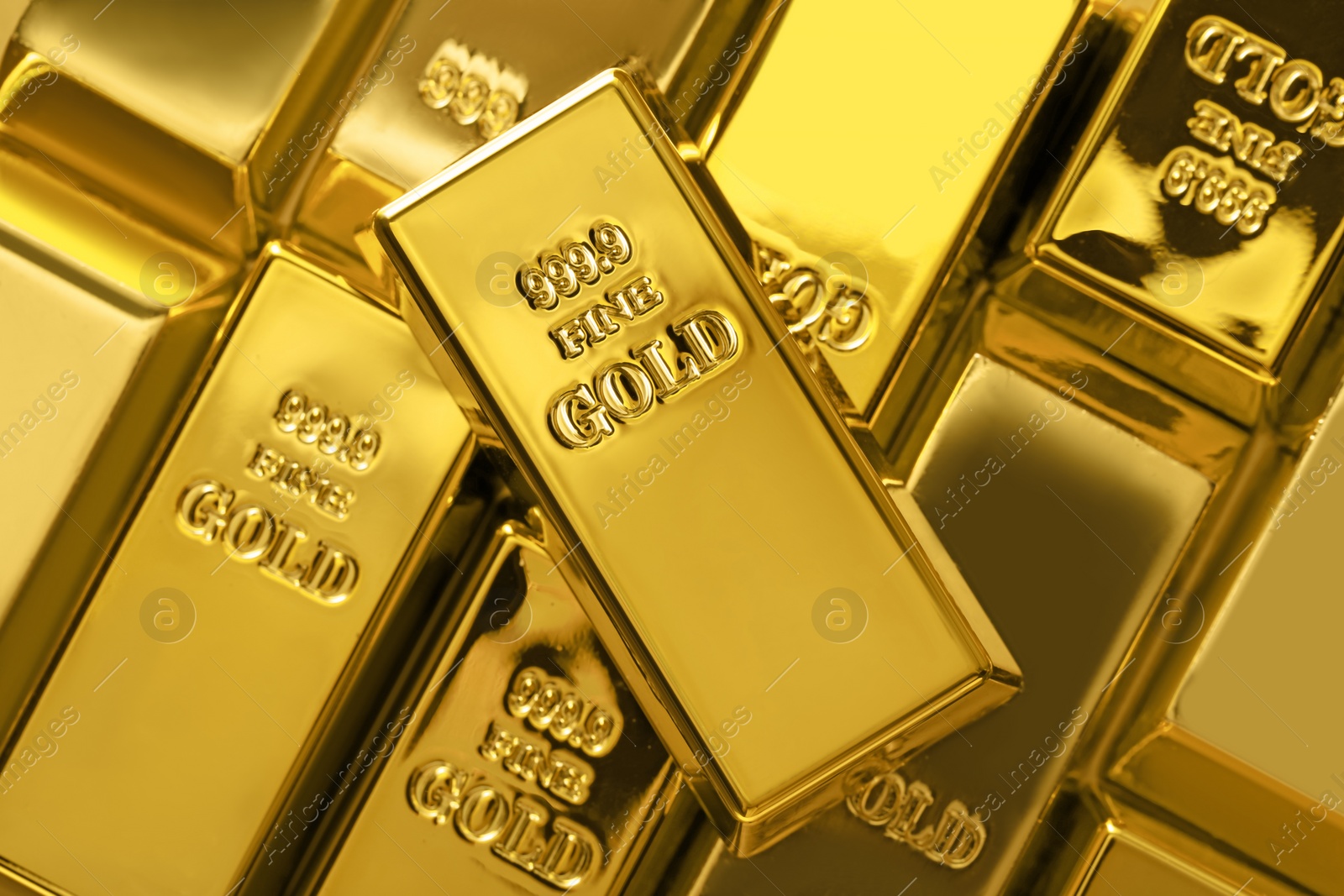 Photo of Many shiny gold bars as background, top view