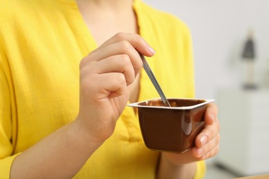 Photo of Woman with container of tasty yogurt indoors, closeup