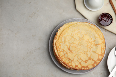 Photo of Flat lay composition with fresh thin pancakes on light grey table. Space for text