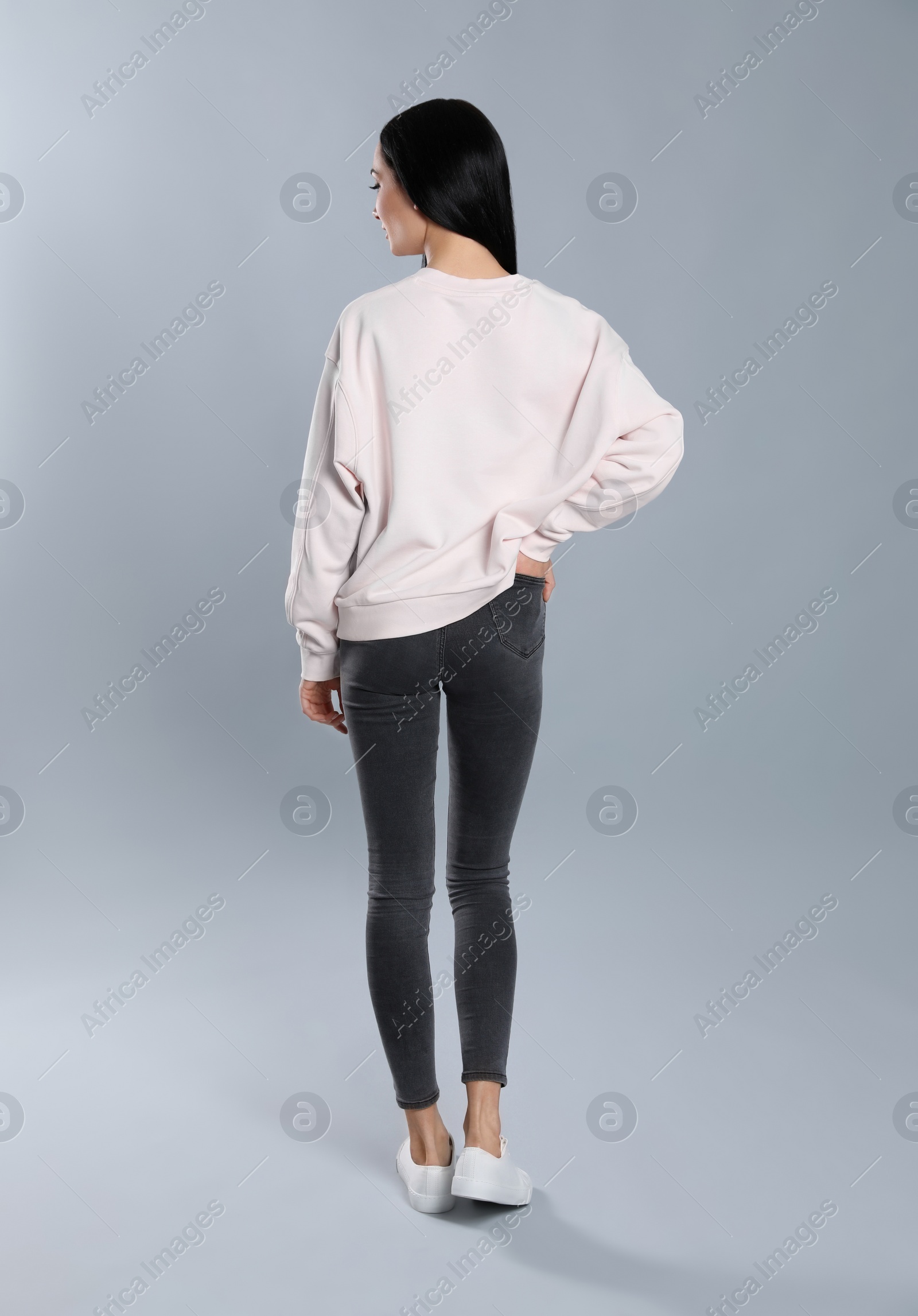 Photo of Young woman in sweater on grey background. Mock up for design