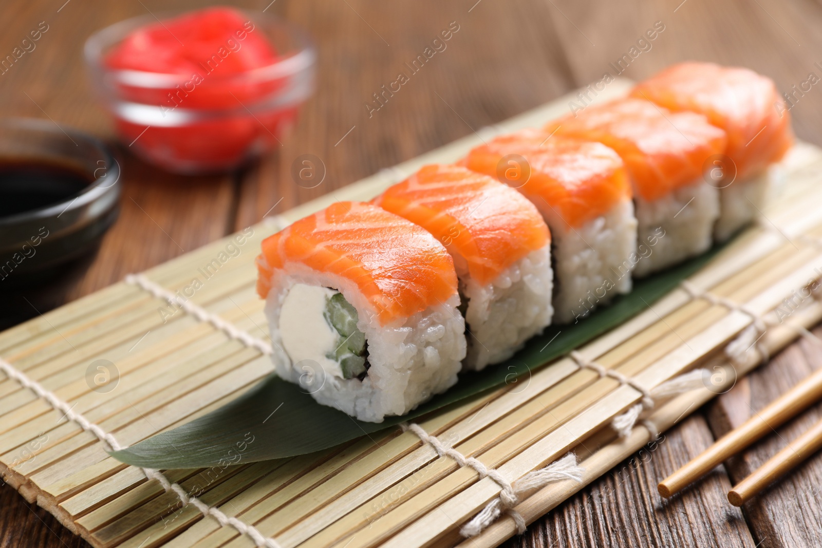 Photo of Tasty sushi rolls served on wooden table, closeup