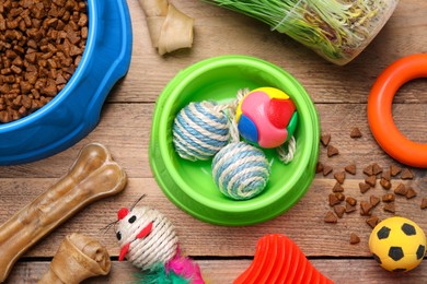 Flat lay composition with pet toys and food on wooden table