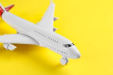 Photo of Toy airplane on yellow background, closeup view