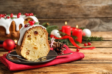 Composition with piece of traditional homemade Christmas cake on wooden table, closeup. Space for text