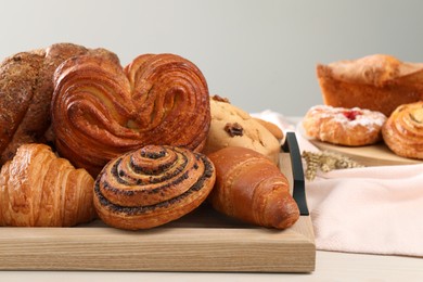 Photo of Different tasty freshly baked pastries on white table