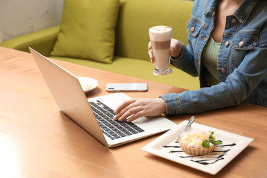 Photo of Blogger working with laptop in cafe, closeup