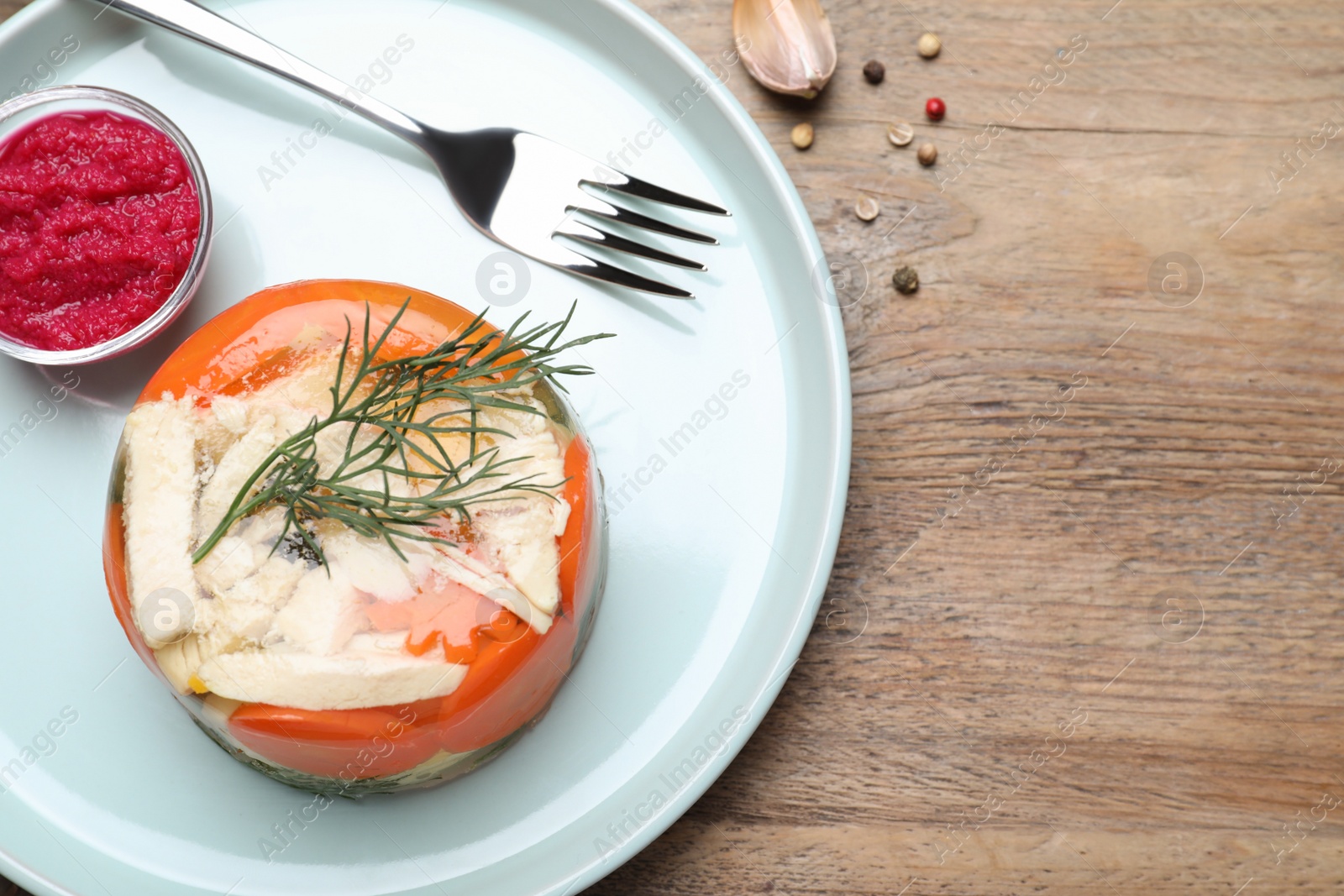 Photo of Delicious chicken aspic served on wooden table, flat lay