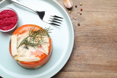 Delicious chicken aspic served on wooden table, flat lay