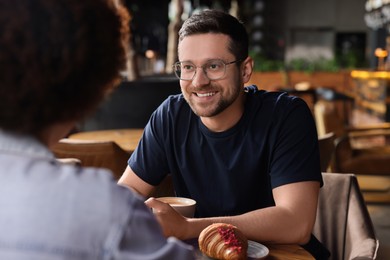 International dating. Lovely couple spending time together in cafe