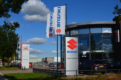 Photo of Veendam, Netherlands - September 21, 2022: Toyota and Suzuki car showroom on sunny day