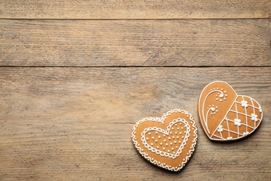 Decorated gingerbread hearts on wooden table, flat lay. Space for text