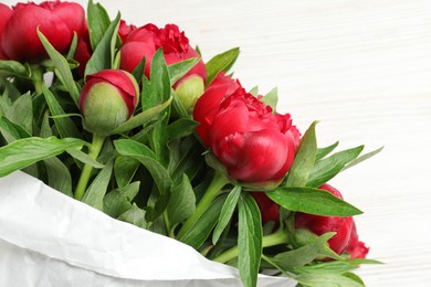 Photo of Beautiful bouquet of red peony flowers on white table, closeup