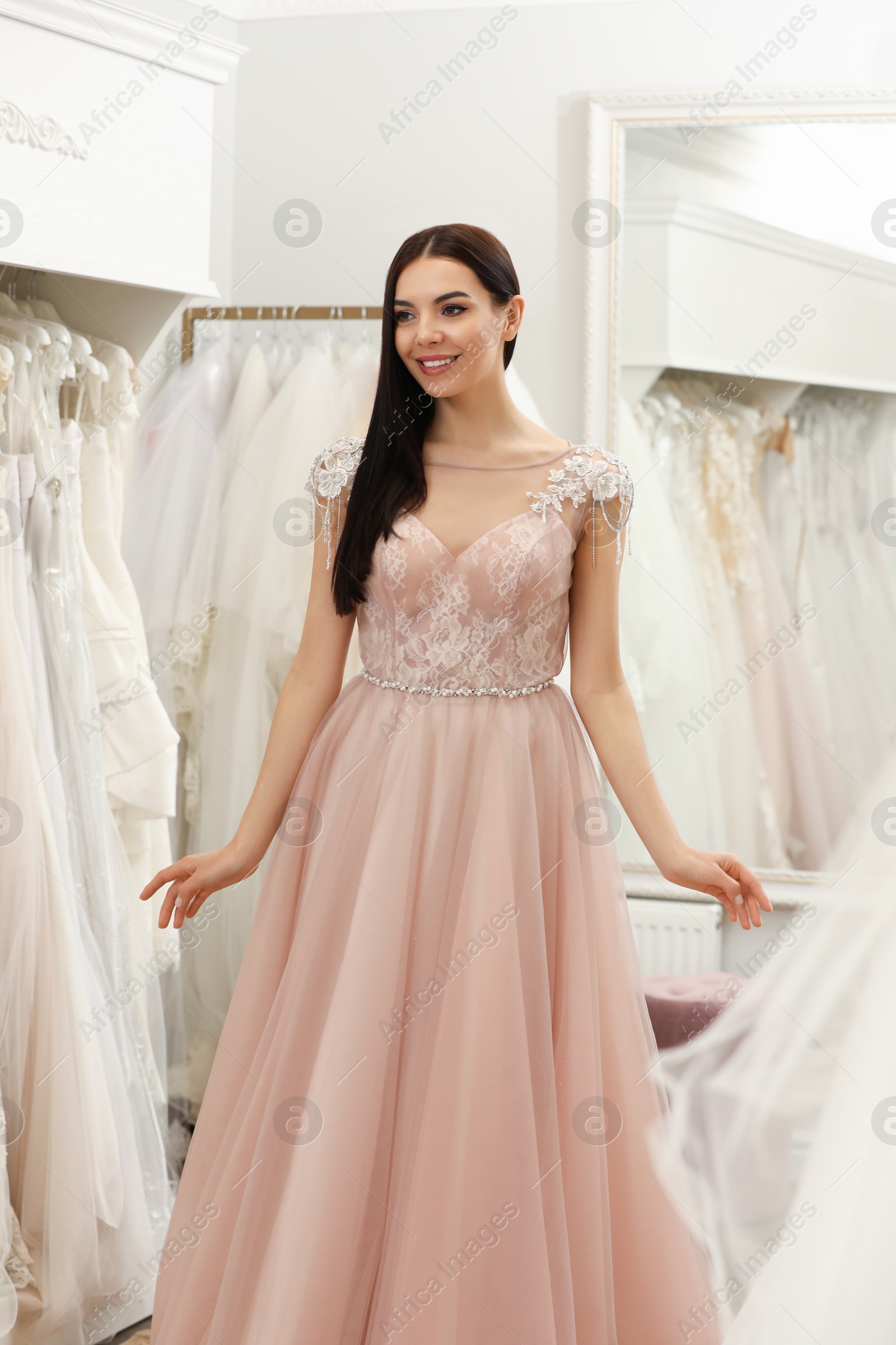 Photo of Woman trying on beautiful wedding dress in boutique