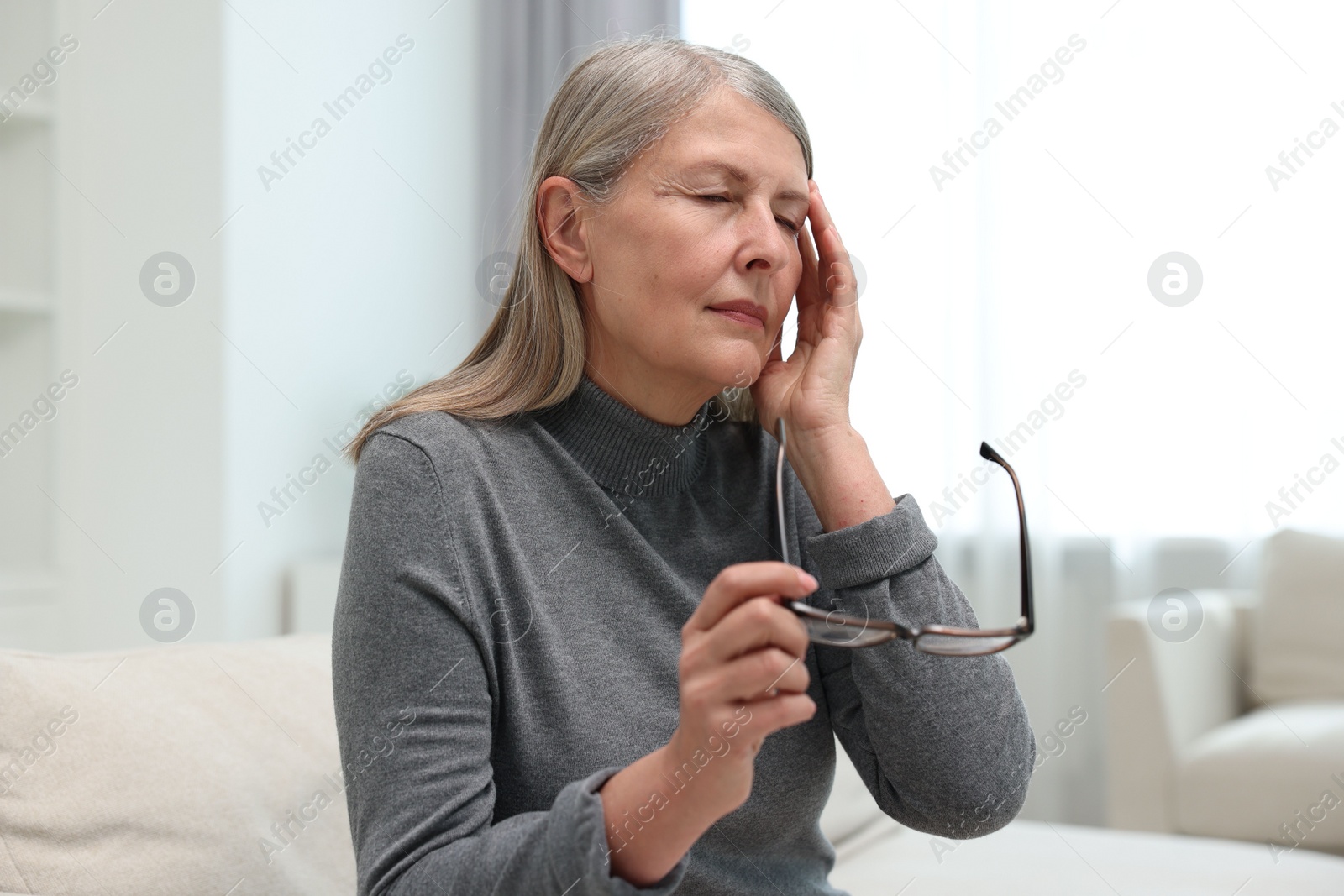 Photo of Overwhelmed woman with glasses suffering at home