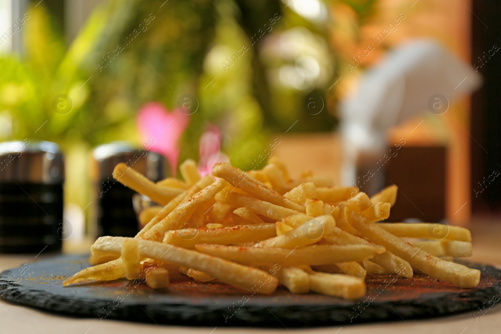 Photo of Delicious hot french fries served on table, closeup