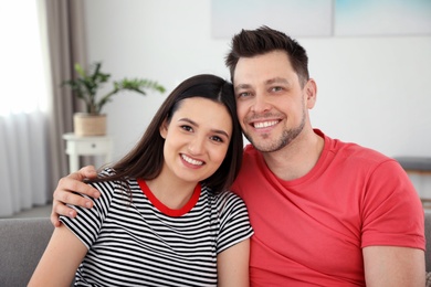 Happy couple hugging and smiling at home