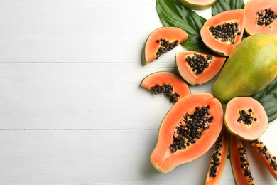 Fresh ripe papaya fruits on white wooden table, flat lay. Space for text