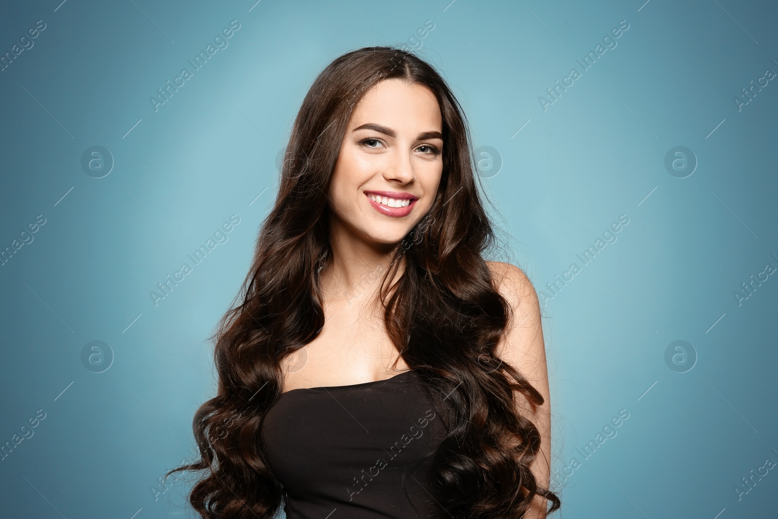 Photo of Portrait of beautiful model with gorgeous curly hair on color background