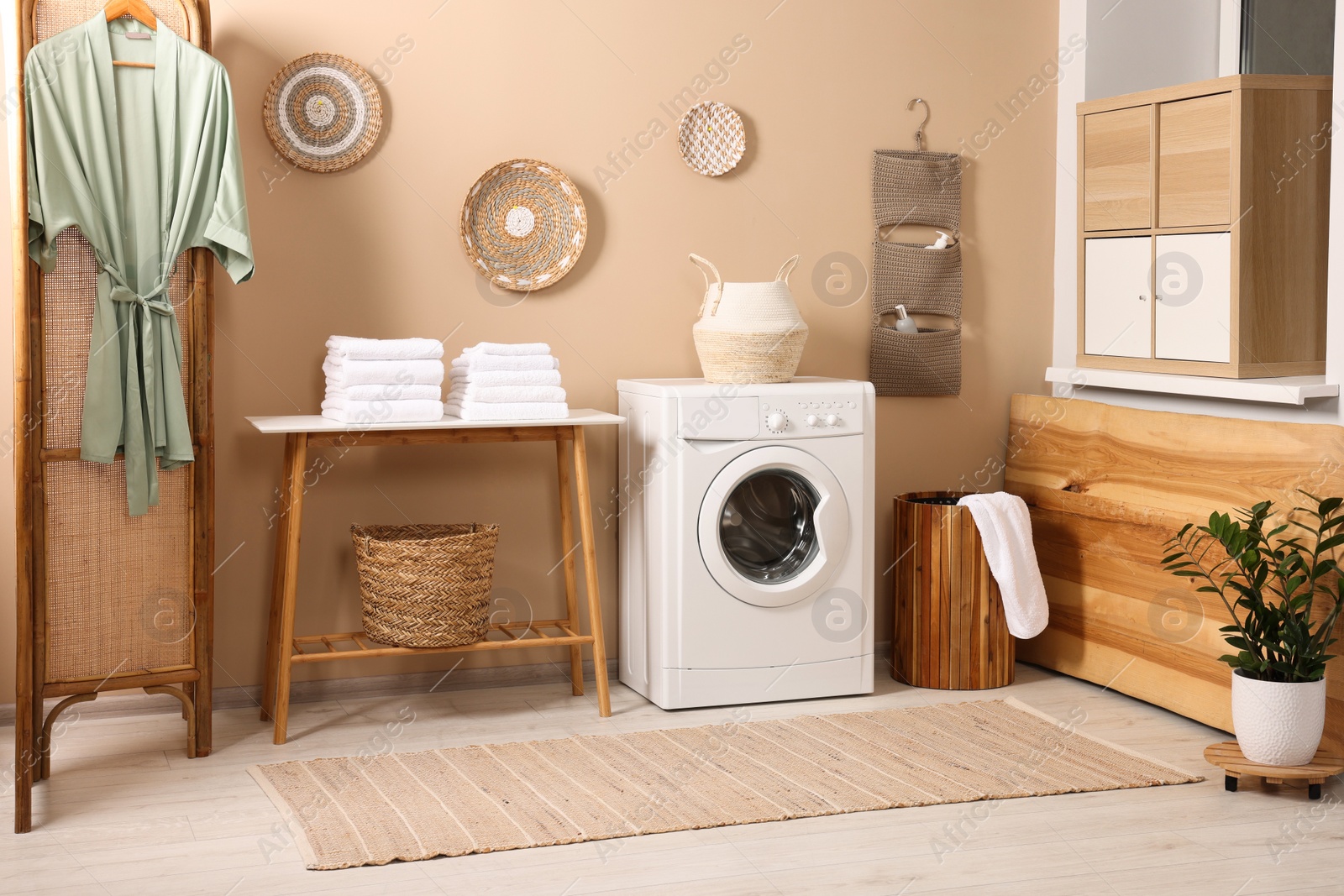 Photo of Stylish laundry room with modern washing machine. Interior design