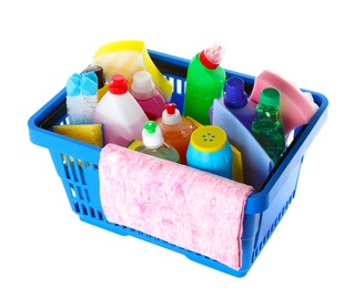 Photo of Shopping basket with different detergents and rag on white background