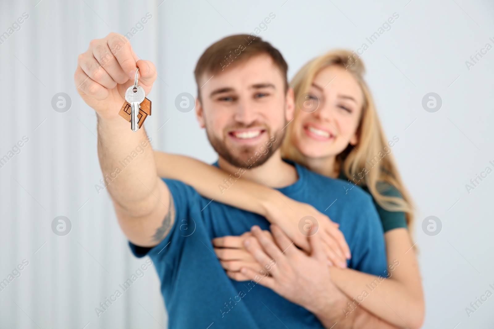 Photo of Happy young couple with key from their new house indoors