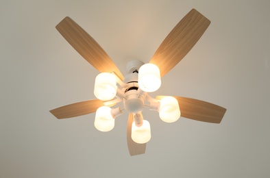 Photo of Modern ceiling fan with lamps, low angle view