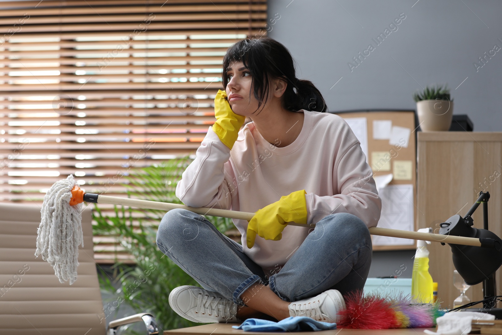 Photo of Lazy woman procrastinating while cleaning at home