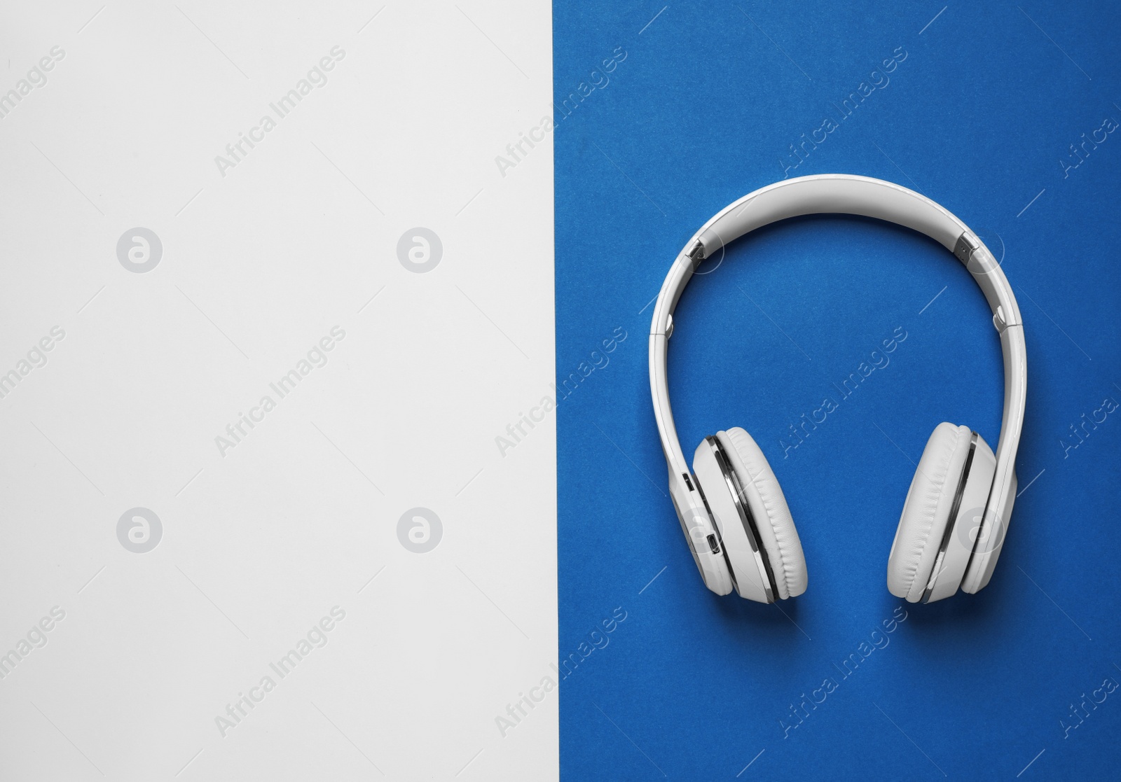 Photo of Headphones on bright background, top view with space for text. Color of the year 2020 (Classic blue)