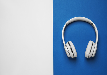 Headphones on bright background, top view with space for text. Color of the year 2020 (Classic blue)