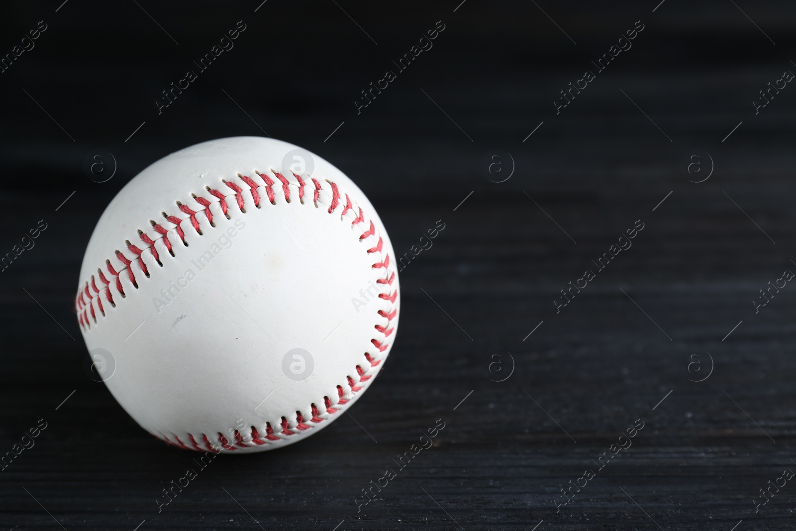 Photo of Baseball ball on black background, closeup with space for text. Sports game