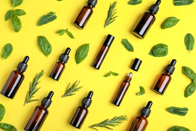 Photo of Flat lay composition with herbal essential oils on yellow background