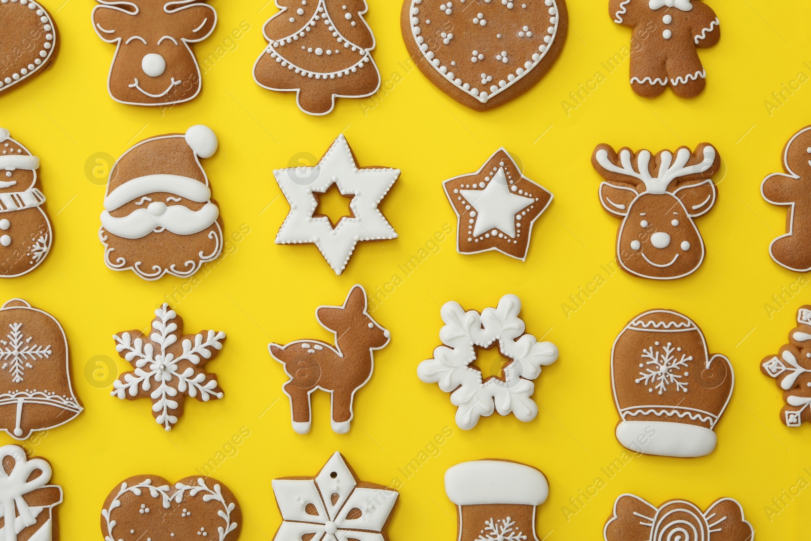 Photo of Different Christmas gingerbread cookies on yellow background, flat lay