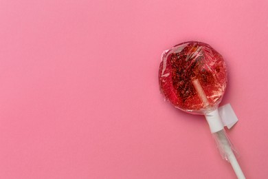 Photo of Sweet colorful lollipop with berries on pink background, top view. Space for text