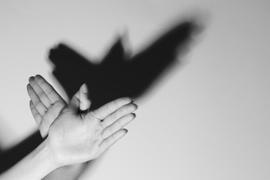 Photo of Woman making hand gesture like bird on light background, closeup with space for text. Black and white effect
