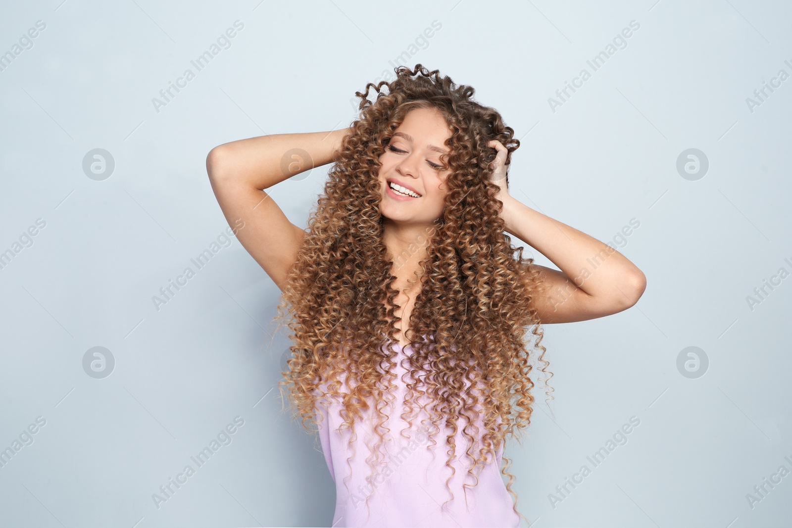 Photo of Portrait of beautiful young woman with shiny wavy hair on color background