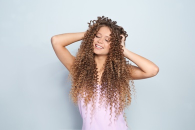 Photo of Portrait of beautiful young woman with shiny wavy hair on color background