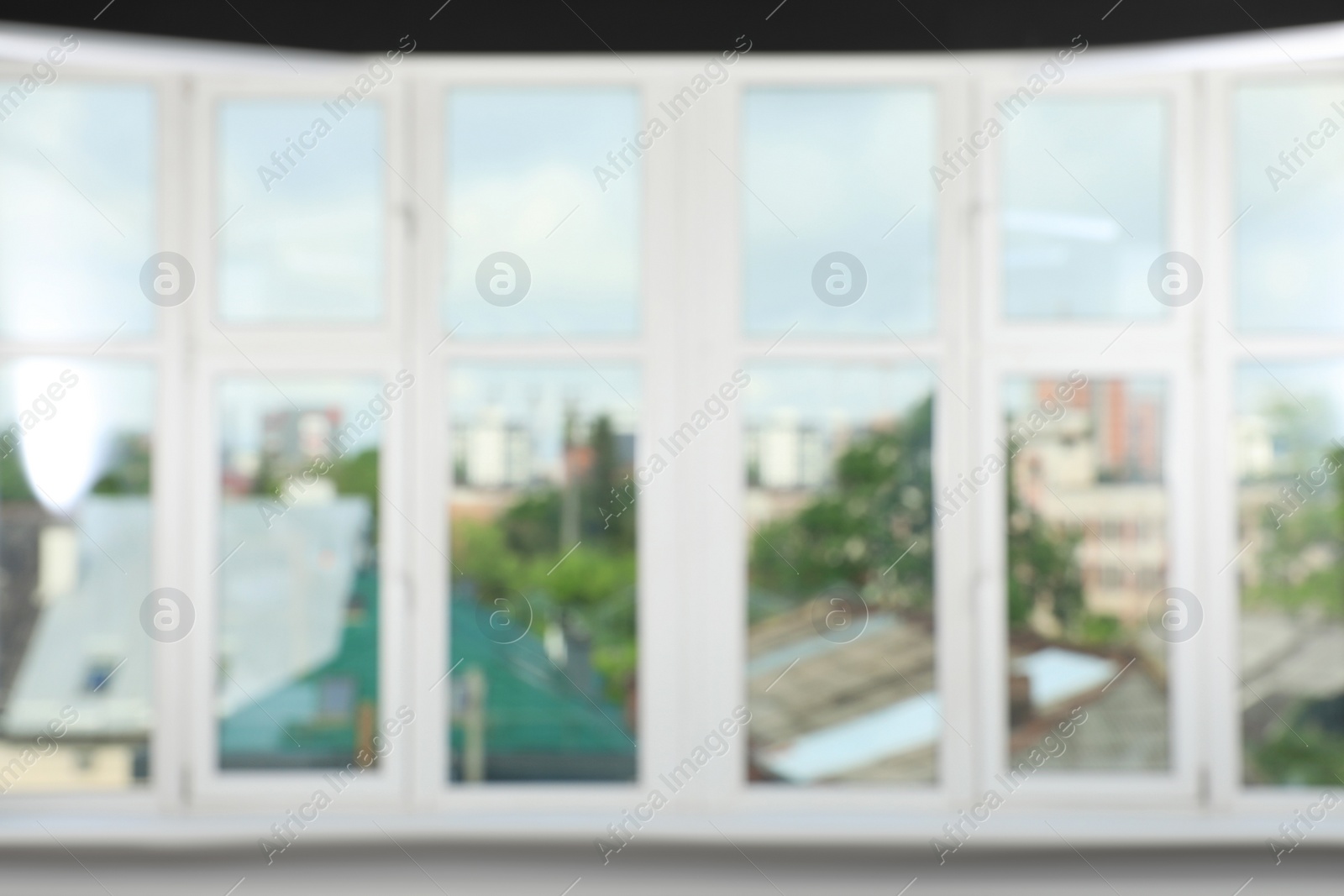 Photo of Blurred view of cityscape through white windows