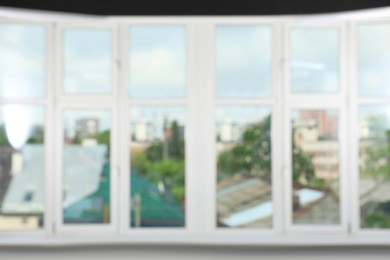 Photo of Blurred view of cityscape through white windows