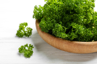 Fresh curly parsley on white wooden table, closeup