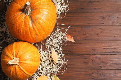 Photo of Flat lay composition with pumpkins and space for text on wooden background. Autumn holidays