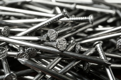 Photo of Pile of metal nails as background, closeup