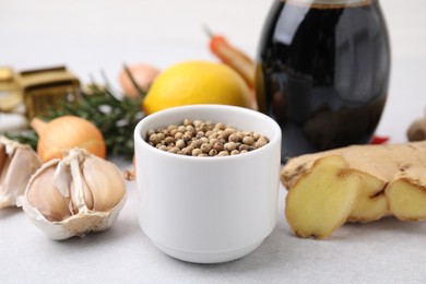 Photo of Aromatic peppercorns and different fresh ingredients for marinade on light grey table