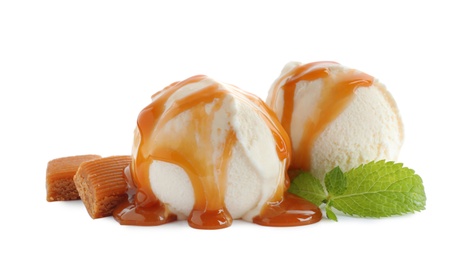 Photo of Delicious ice cream with caramel sauce, candies and mint on white background