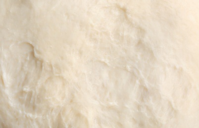 Photo of Fresh raw dough as background, closeup