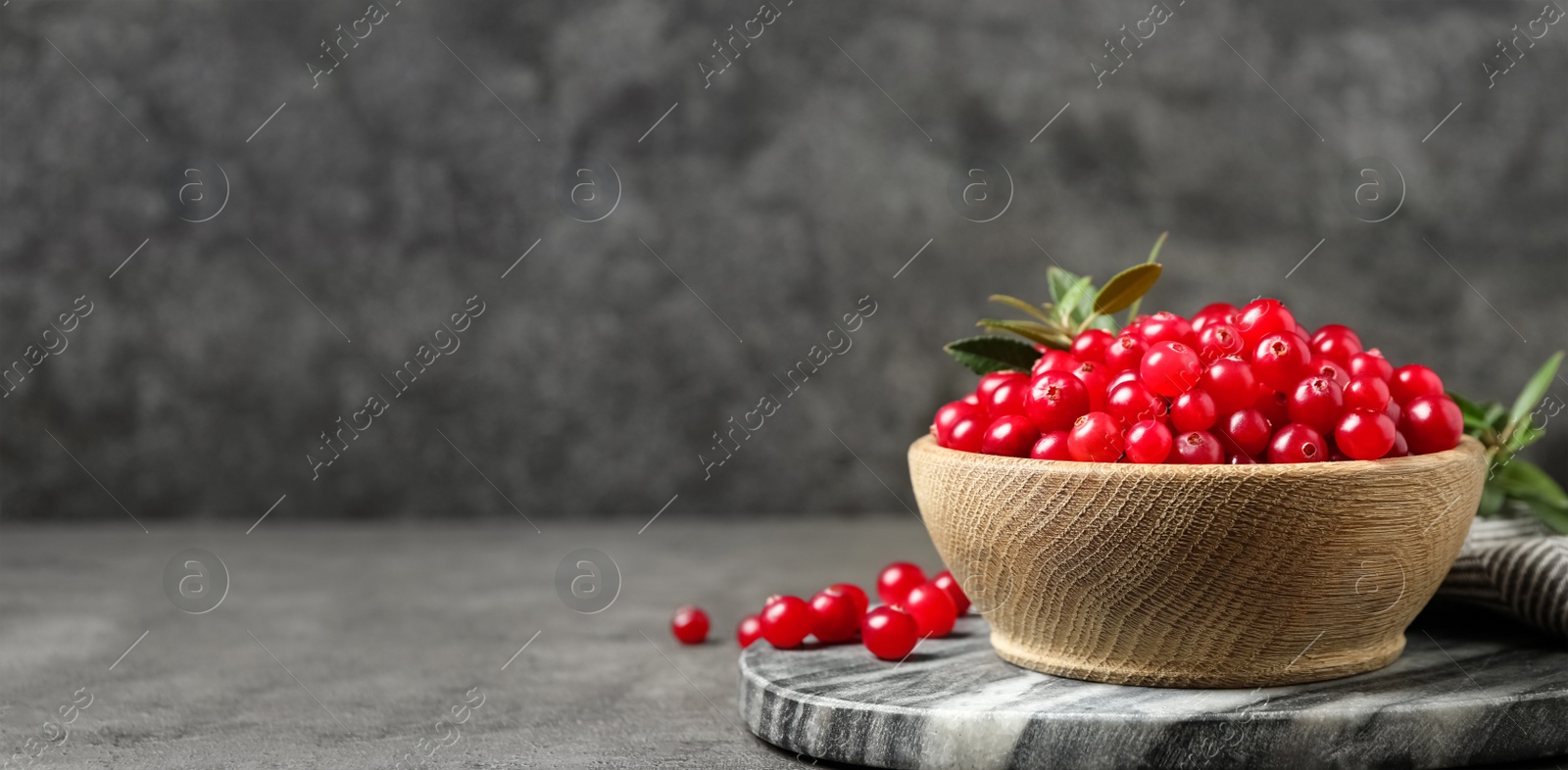 Image of Tasty ripe cranberries on grey table, space for text. Banner design