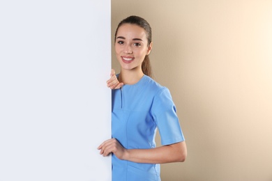 Photo of Medical student with blank poster on color background. Space for text
