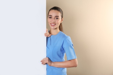 Medical student with blank poster on color background. Space for text